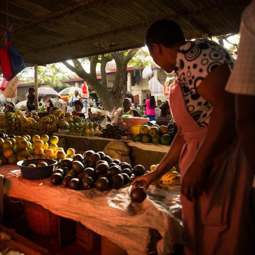 A woman samples fruit for sale at an open air market in Kisumu, Kenya.