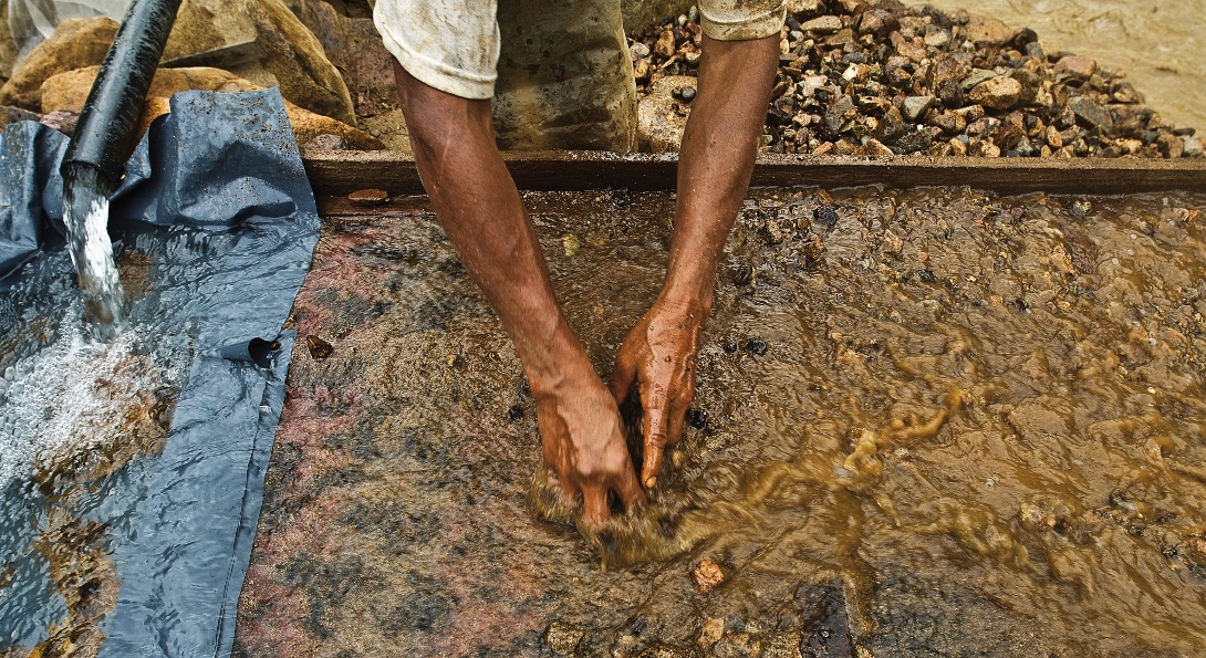A small-scale gold miner sifts through water and rocks in Zamora-Chinchipe, Ecuador in December 2007.